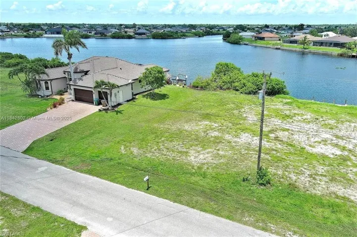 Aerial view of residential area featuring a nearby body of water