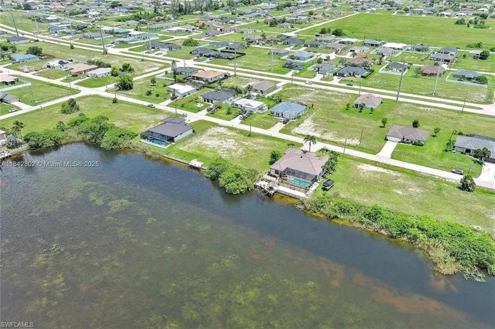 Aerial view of property's location featuring a large body of water and nearby suburban area