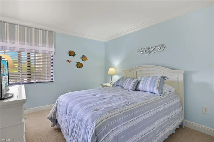 Bedroom with light colored carpet and ornamental molding