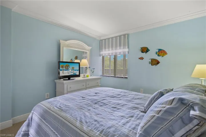 Carpeted bedroom with ornamental molding