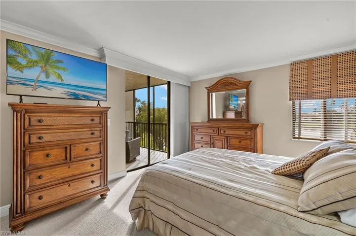 Carpeted bedroom with access to exterior and crown molding