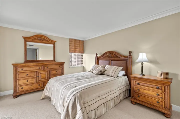 Carpeted bedroom featuring crown molding