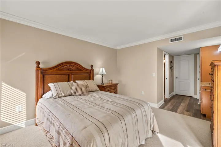 Bedroom featuring dark hardwood / wood-style flooring and crown molding