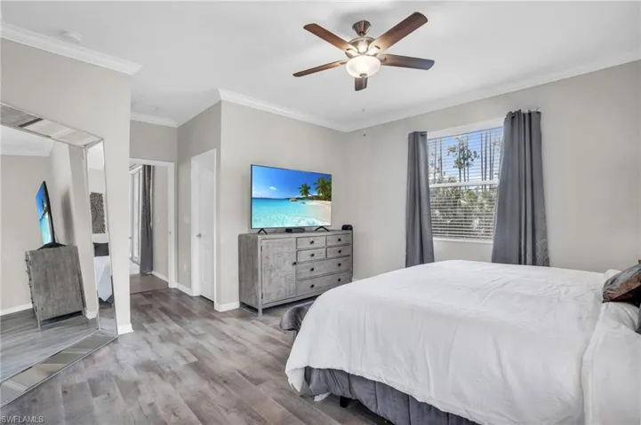 Bedroom featuring ceiling fan, ornamental molding, and light hardwood / wood-style flooring