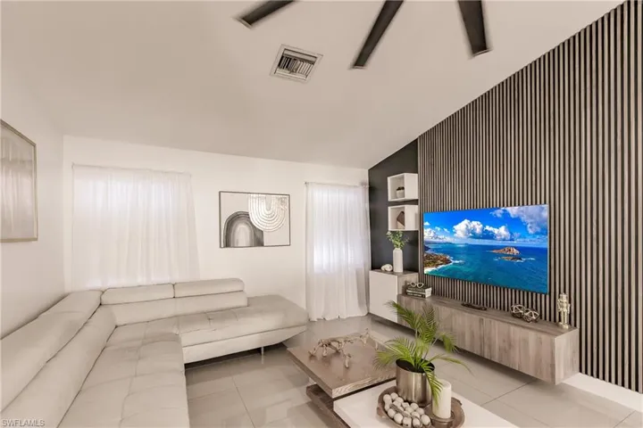 Living room with vaulted ceiling and light tile patterned flooring