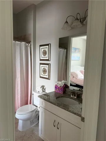 Full bath with ensuite bathroom, vanity, a shower with curtain, and light tile patterned floors