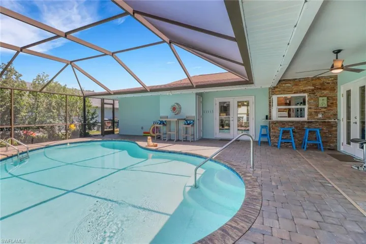 Swimming pool with french doors, a lanai, a patio area, and a sunroom