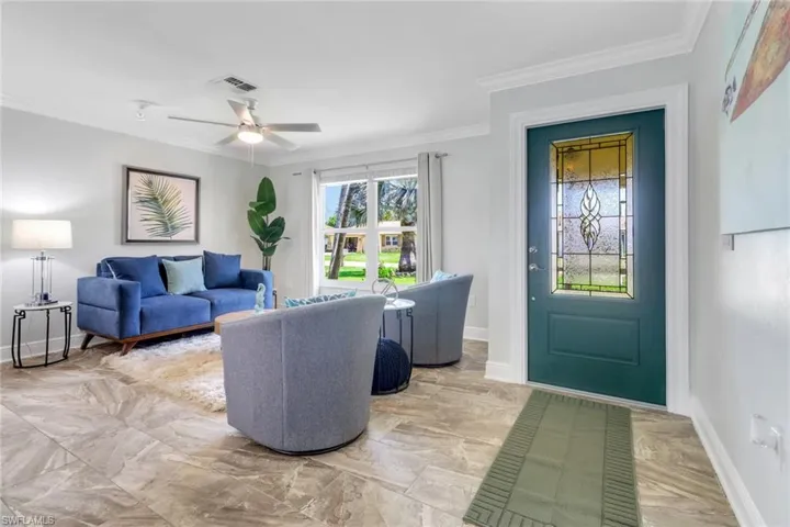 Living area featuring crown molding and a ceiling fan