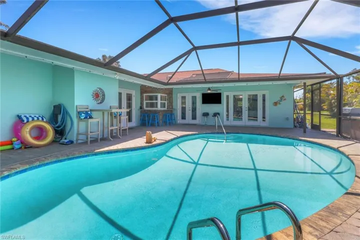 Outdoor pool featuring french doors, a lanai, and a sunroom