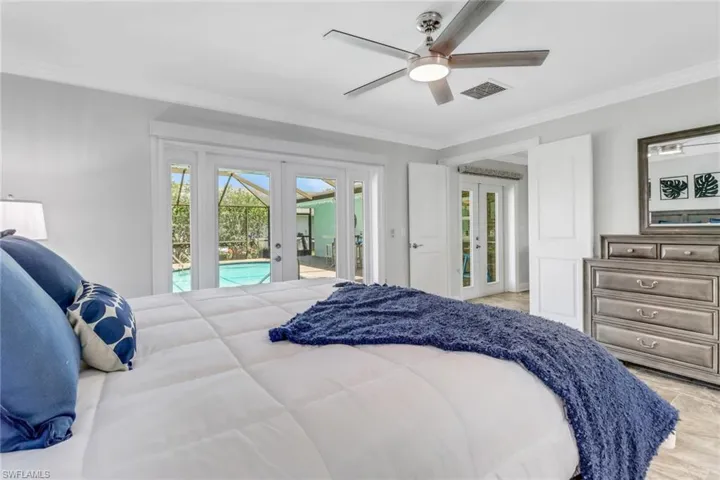 Bedroom featuring french doors, access to exterior, multiple windows, and crown molding