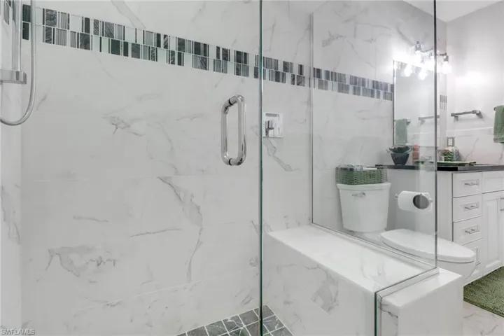 Full bathroom featuring vanity and a marble finish shower