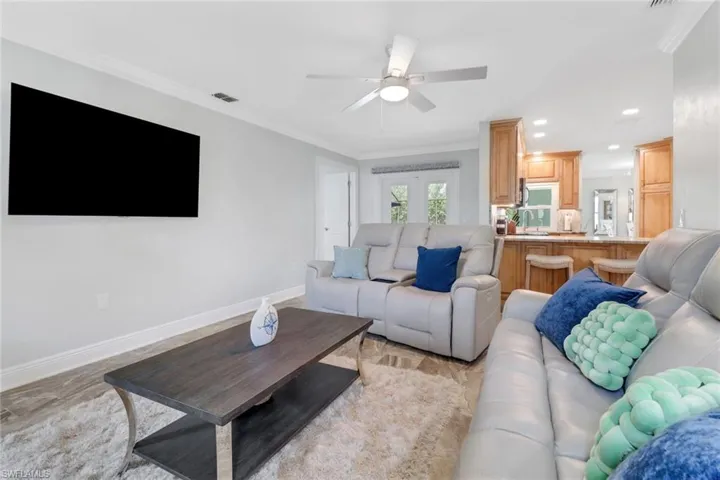 Living room with crown molding, recessed lighting, and a ceiling fan