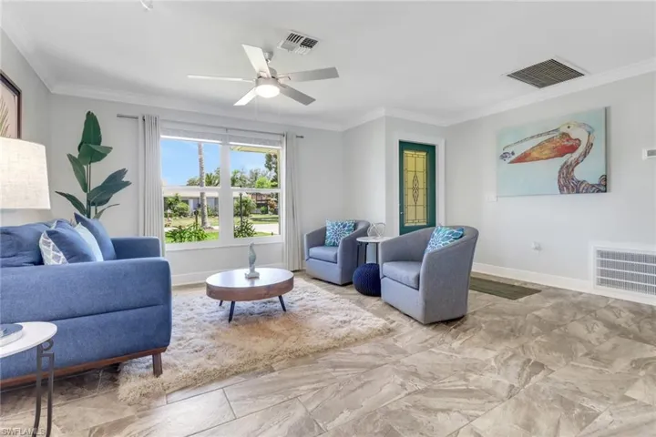Living room featuring ornamental molding and ceiling fan