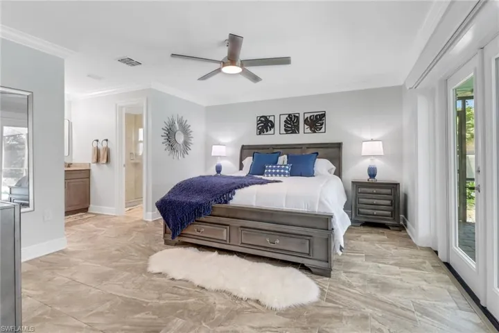 Bedroom with access to outside, crown molding, a ceiling fan, and ensuite bath