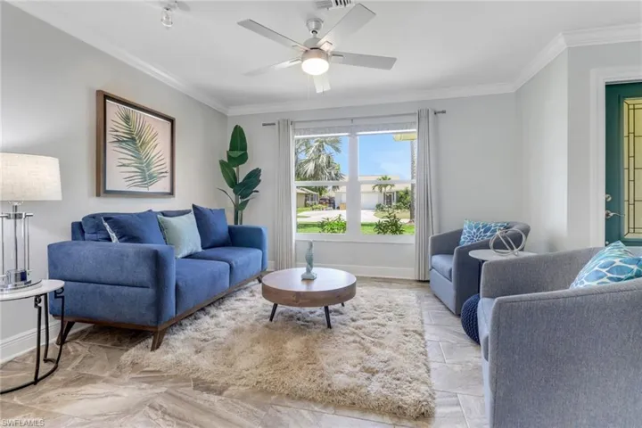 Living room featuring crown molding and ceiling fan