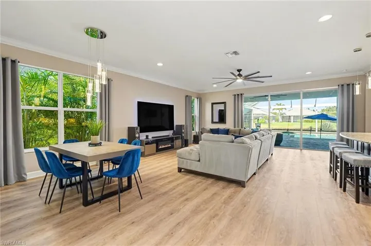 Living area with light wood-type flooring, ornamental molding, a ceiling fan, and recessed lighting