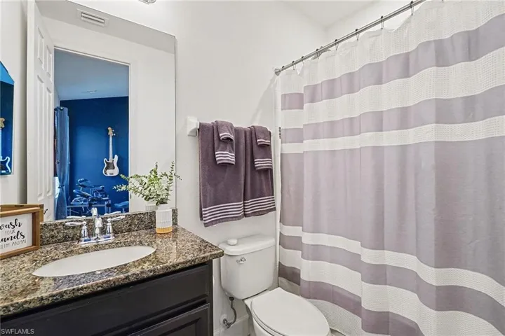 Full bath with a shower with shower curtain and vanity