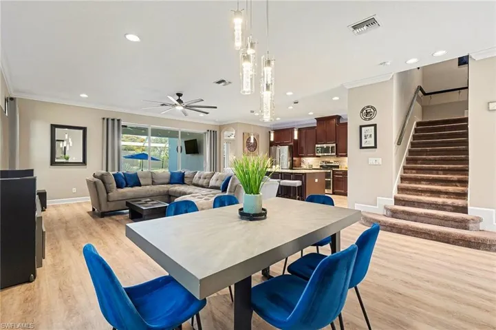Dining area with light wood-style flooring, ornamental molding, a ceiling fan, stairway, and recessed lighting