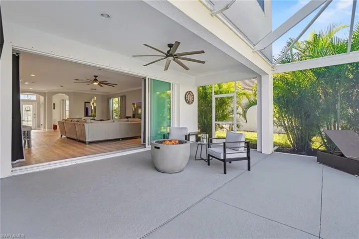 View of patio / terrace with a ceiling fan and an outdoor living space with a fire pit