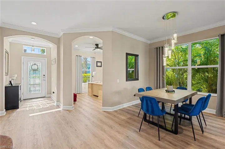 Dining area featuring ornamental molding, a ceiling fan, light wood-style floors, plenty of natural light, and recessed lighting