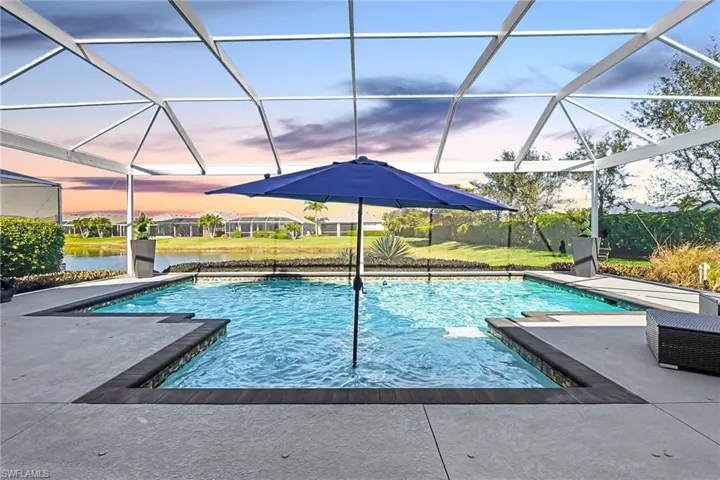 Screen-enclosed pool area featuring a lakefront setting