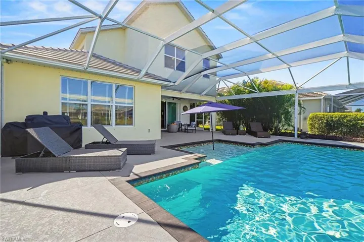 Outdoor pool featuring a patio area, glass enclosure, and a sunroom