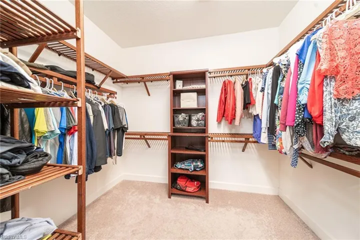 Walk in closet featuring light colored carpet