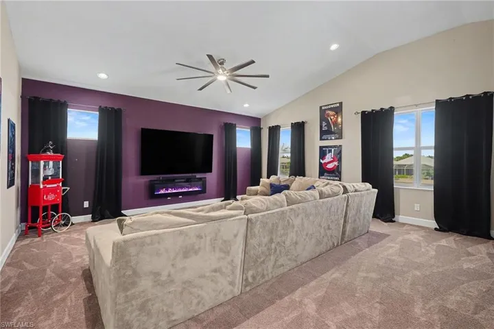 Living room with carpet, recessed lighting, ceiling fan, and vaulted ceiling