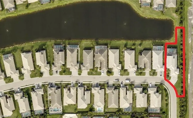 Aerial view of residential area featuring a large body of water and property parcel outlined