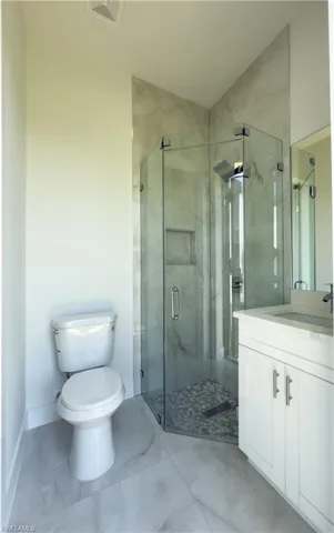 Full bathroom with vanity and a marble finish shower