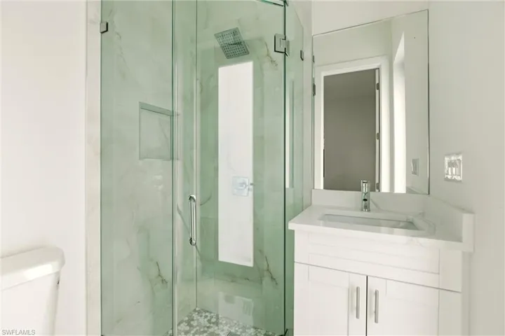 Bathroom with a marble finish shower and vanity