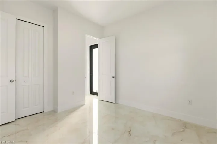 Unfurnished bedroom with light marble finish flooring and a closet