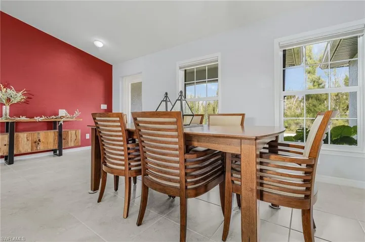 Dining area featuring lofted ceiling and an accent wall