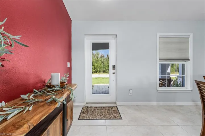 Entrance foyer featuring baseboards and light tiled floors