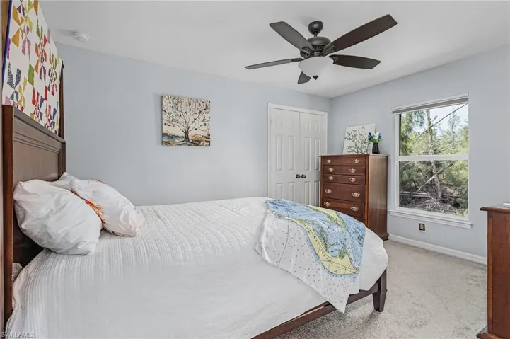Carpeted bedroom with a closet and a ceiling fan