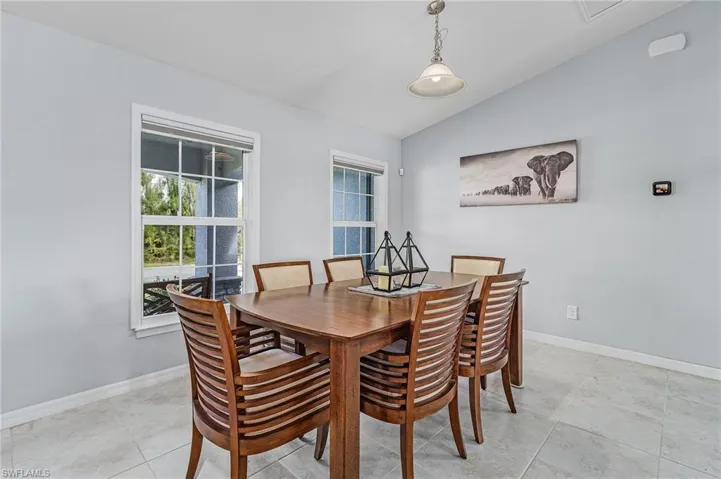 Dining room with lofted ceiling and baseboards