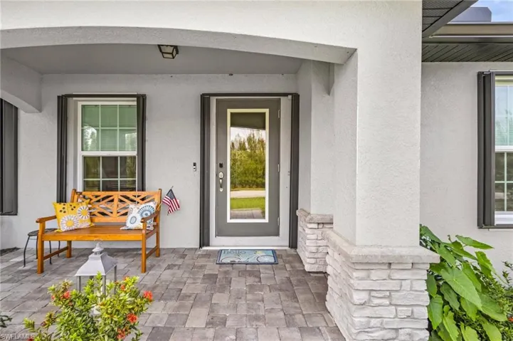 Doorway to property featuring stucco siding and a porch