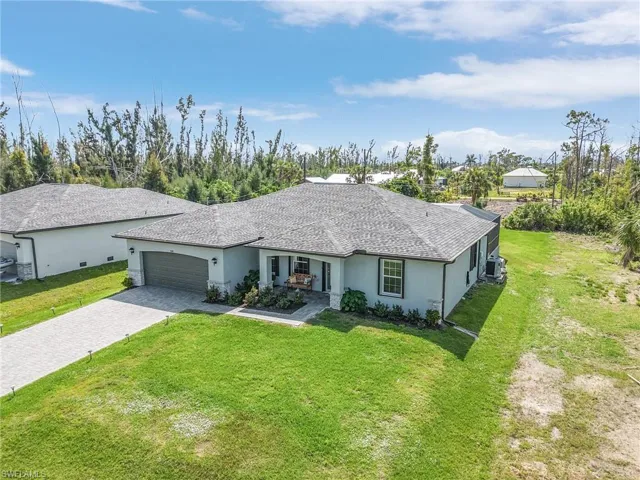 Single story home featuring stucco siding, a front lawn, decorative driveway, an attached garage, and roof with shingles