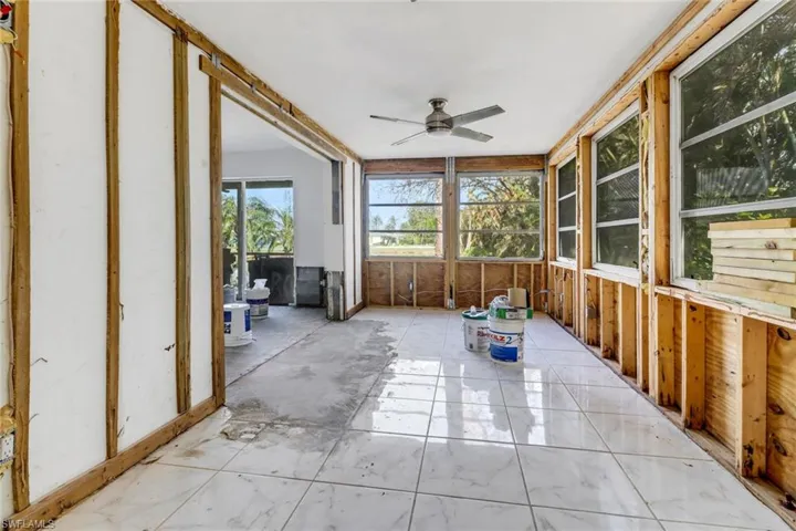 Unfurnished sunroom featuring ceiling fan