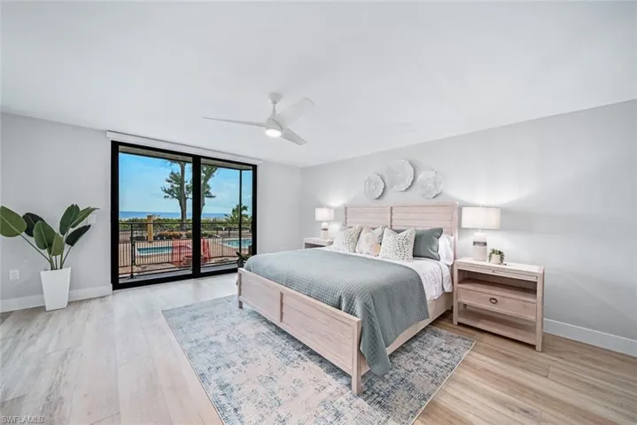 Bedroom with ceiling fan, a water view, access to outside, and floor to ceiling sliders
