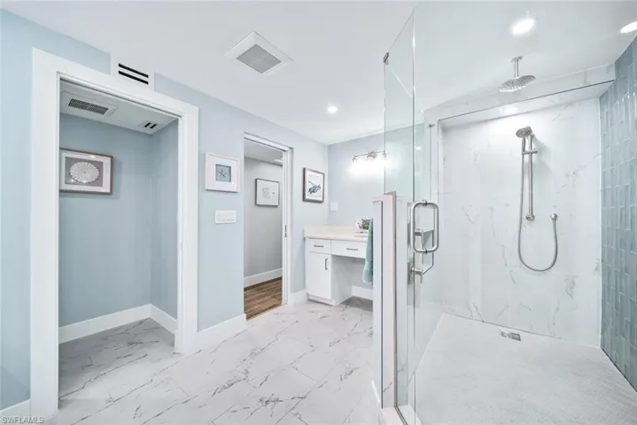 Bathroom featuring tile flooring, a shower with shower door, and vanity