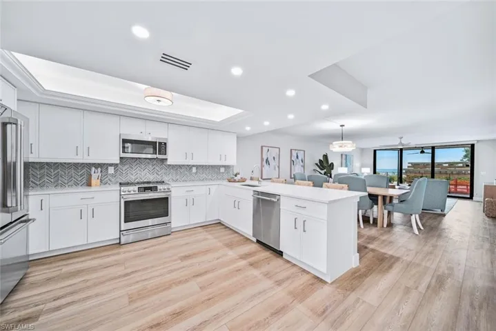 Kitchen featuring light hardwood / wood-style flooring, kitchen peninsula, and stainless steel appliances