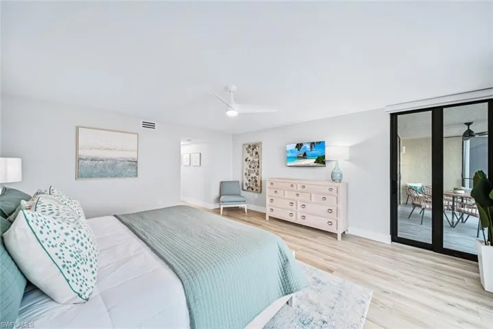 Bedroom with access to outside, multiple windows, light wood-type flooring, and ceiling fan