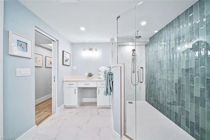 Bathroom featuring tile floors, a shower with shower door, and vanity