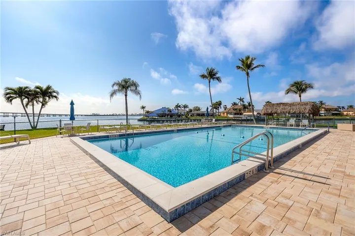 Community pool featuring a patio area and a water view