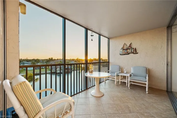 Sunroom / solarium with plenty of natural light, a water view, floor to ceiling windows, and tile patterned flooring