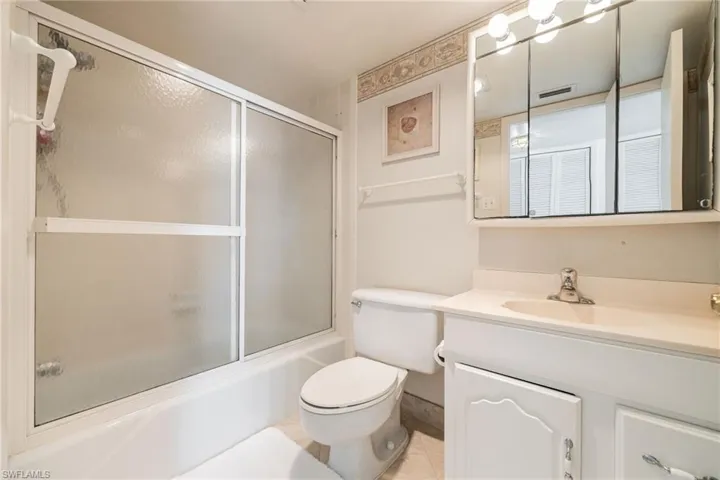 Full bath with vanity and combined bath / shower with glass door