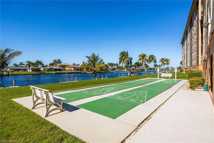 View of property's community featuring shuffleboard, a water view, and a residential view