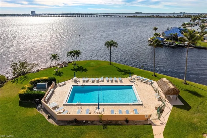 Community pool with a water view, a yard, and a patio