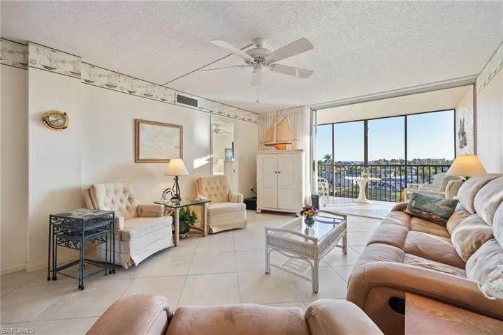 Living area with a textured ceiling, a ceiling fan, and tile patterned flooring